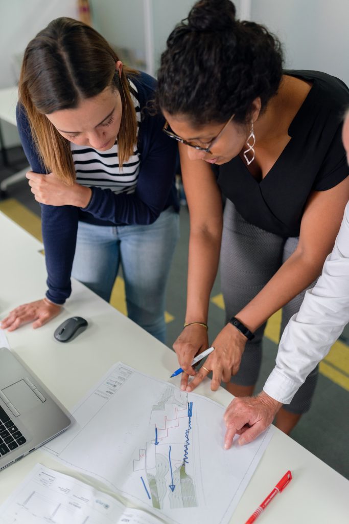 woman in black shirt and blue denim jeans writing on white paper